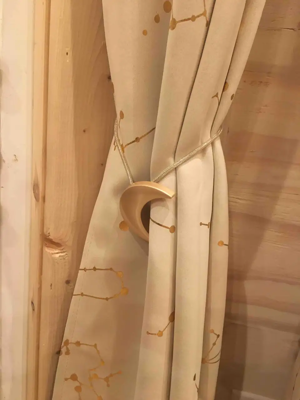 Curtain tied back with a crescent moon